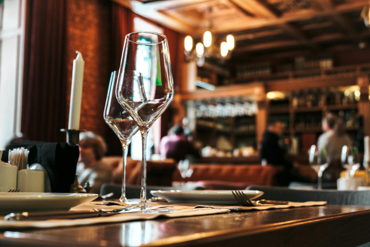 Elegant wine glasses and cozy restaurant ambiance create a sophisticated dining experience.