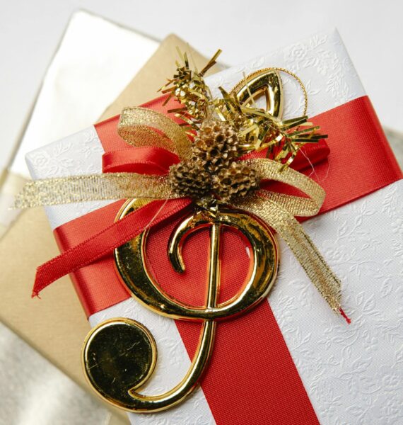 Top view of golden treble clef on present boxes with ribbons and pine cones during New Year holiday